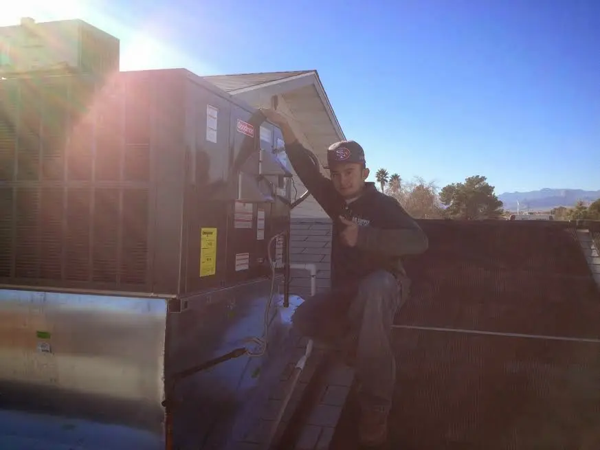 HVAC technician performing AC Tune-Up on a rooftop unit in Kendale Lakes